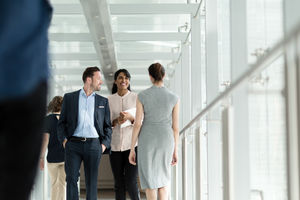 Business colleagues walking through busy office corridor