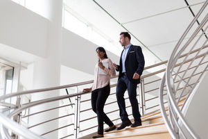 Business colleagues walking down spiral staircase
