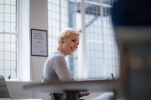 Young female businesswoman taking notes in meeting