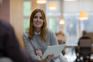 Businesswoman in a meeting holding a digital tablet