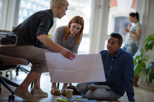Colleagues looking at plans together in a meeting