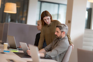 Coworkers looking at a laptop together
