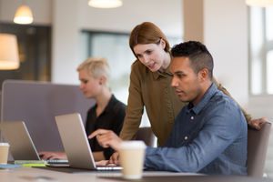 Manager training new employee in office