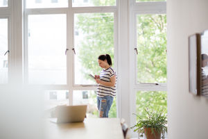 Businesswoman in empty office looking at smartphone
