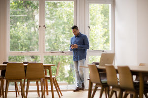 Businesswoman in empty office looking at smartphone