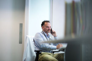 Male Medical Doctor on phone in his office