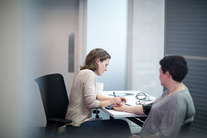 Female Medical Doctor taking an overweight patients blood pressure
