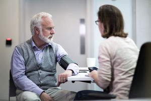 Female Medical Doctor taking a Senior patients blood pressure