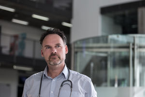 Portrait of Male Doctor walking through Hospital