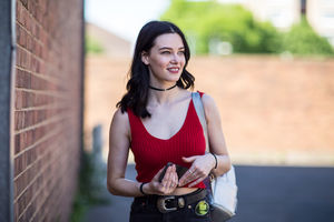 Young adult female turning to look at camera on street