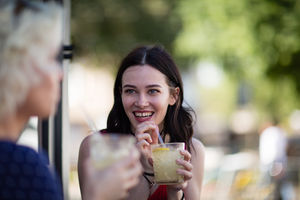Female friends enjoying a refreshing drink outdoors in summer