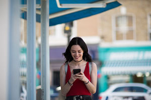 Young adult female using a smartphone whilst shopping