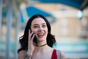 Young adult female walking down street whilst on smartphone
