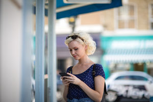 Young adult female using a smartphone whilst shopping