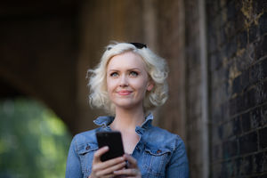 Young adult female using smartphone on street
