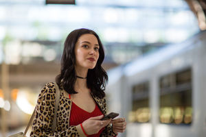 Young adult female on station platform using smartphone