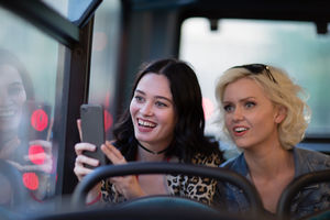 Female friends travelling through London on a bus
