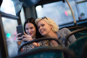 Female friends taking a selfie on a London bus