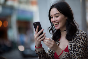 Young adult female on a video call with friend outdoors