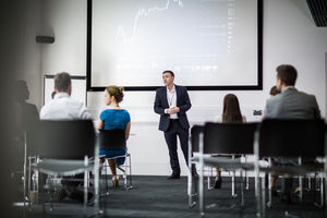 Speaker at a business training conference listening to a question