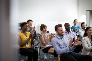 Audience at a conference applauding speaker