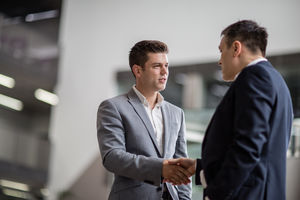 Businessmen shaking hands in a corporate office