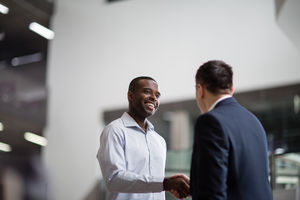 Businessmen shaking hands in a corporate office