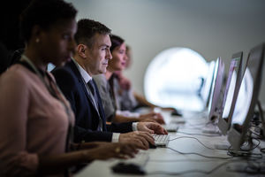 Businessman using computer in crowded office