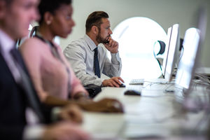 Businessman using computer in crowded office