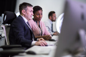 Colleagues in an office looking at a computer screen together