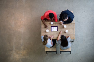 Overhead shot of a team using a digital tablet in a business meeting