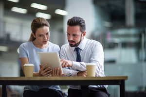 Colleagues using a digital tablet in a meeting
