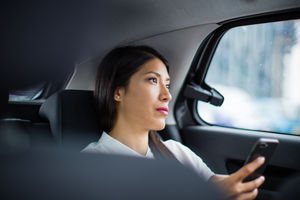 Businesswoman looking out of window of taxi cab