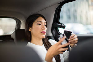 Businesswoman paying via app for taxi cab ride