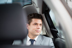 Businessman looking out of window of taxi cab