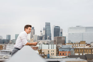 Businessman looking out at London city skyline