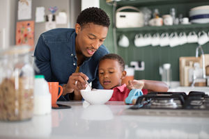 Dad helping son with breakfast