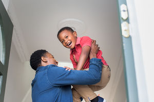 Dad lifting son up as he welcomes him home
