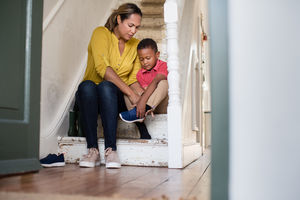 Mum helping son with his shoes