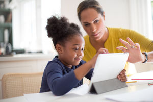 Mother teaching Daughter how to use digital tablet