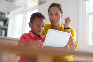 Mother teaching Son how to use digital tablet