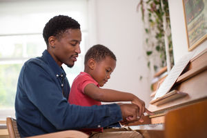 Father teaching Son to play the piano