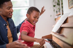 Father teaching Son to play the piano