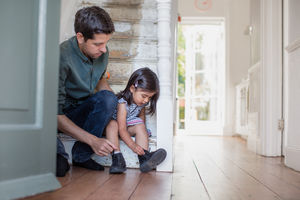 Dad helping daughter with her shoes