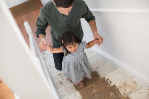 Father helping Daughter walk up stairs