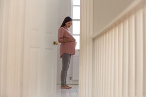 Pregnant woman standing in nursery room