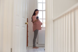 Pregnant woman taking selfie with smartphone