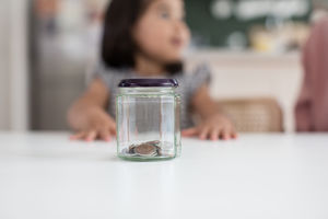 Girl saving her pocket money in a jar