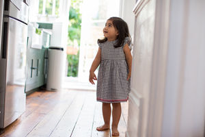 Girl looking up to a refrigerator cheekily