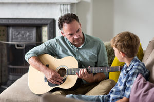 Father teaching son how to play guitar